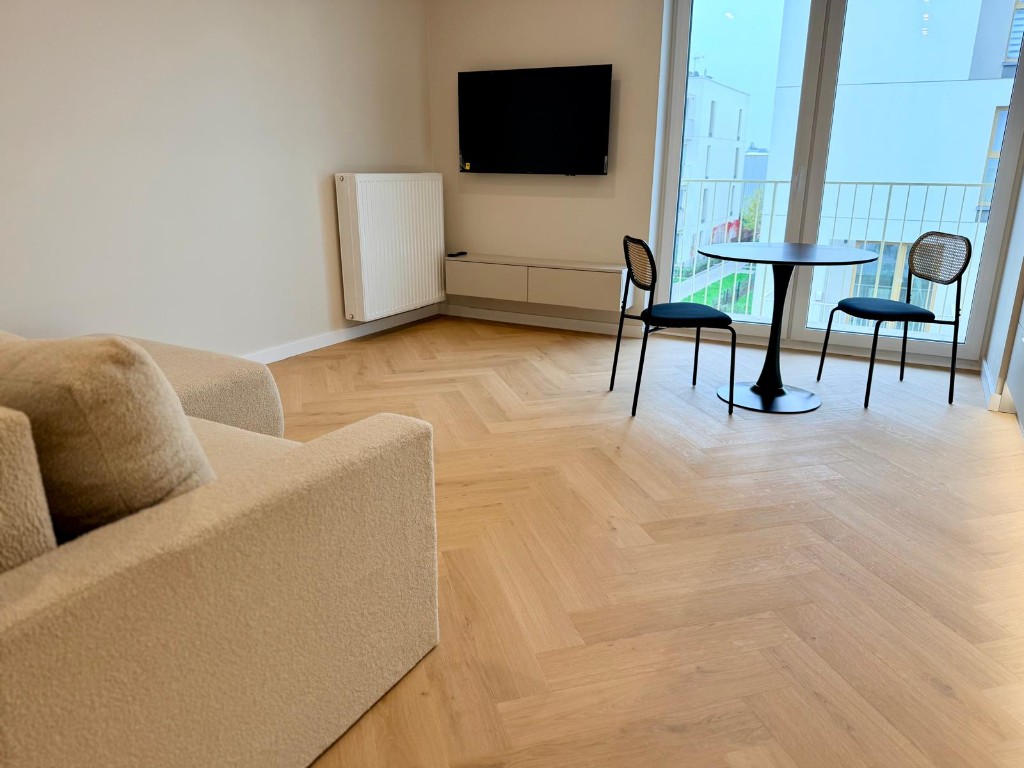 Salon z TV i wyjściem na balkon